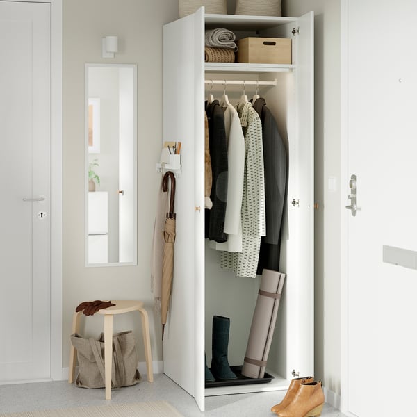 Small white wardrobe with clothes, bags, shoes, mirror.