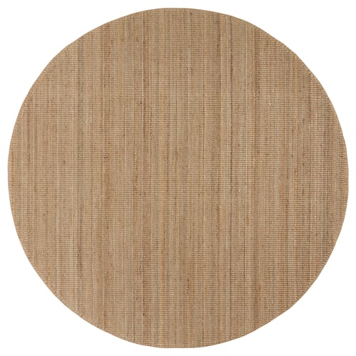 A circular, natural-colored jute rug named LOHALS. Its neutral tones create a calm atmosphere.