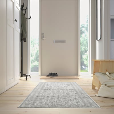 Entryway with grey LOKALTÅG rug, shoes, bench, coat rack, bright light.