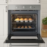 Modern convection oven baking muffins and cookies, showing multiple racks and even heat distribution.
