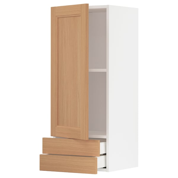 A light wood-colored METOD kitchen cabinet with two drawers and two shelves. It a simple, modern design with oak finish.