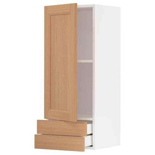 A light wood-colored METOD kitchen cabinet with two drawers and two shelves. It a simple, modern design with oak finish.