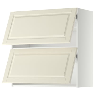 Two white overhead kitchen cabinets with bevelled edges and one open door revealing shelves.