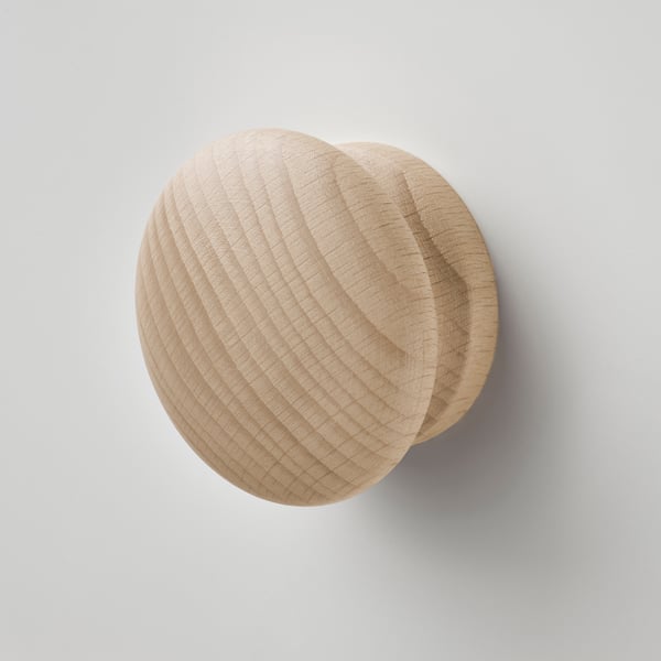 Smooth, light wood knobs on light grey wall.
