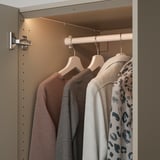 A modern wardrobe with led lights, illuminating clothes hangers inside. The lights automatically adjust when the door is opened or closed.