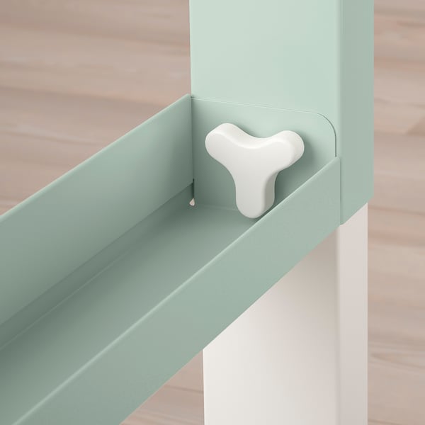 Light green modern desk with adjustable shelf, wooden floor background.