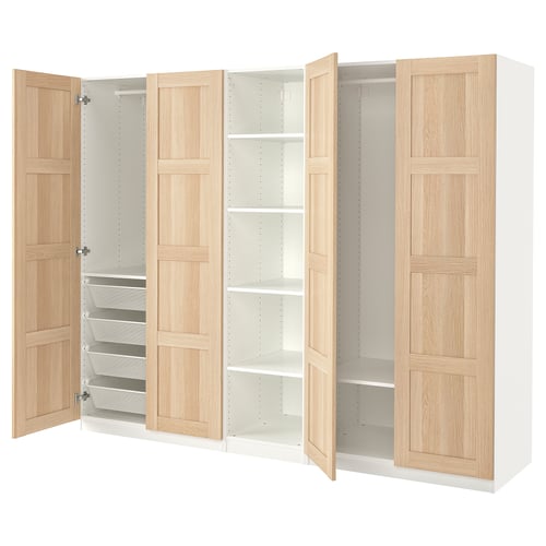 A white PAX wardrobe with light wooden doors. It open sections revealing shelves and wire baskets for storage.