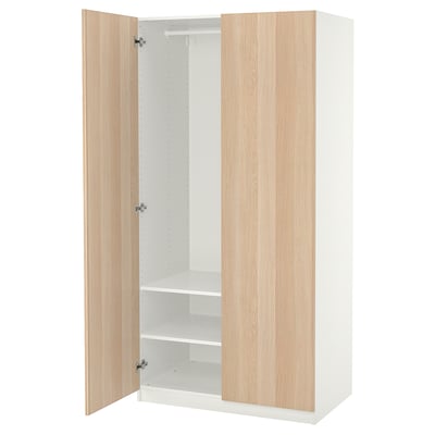 An ikea PAX wardrobe with light oak doors and a white frame, open to display white interior shelves and a hanging rod.