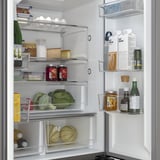 Fridge with adjustable glass shelves, led lights, and drawers showing fresh produce and dairy.