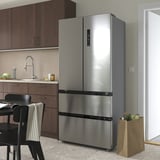 A modern kitchen with a large stainless steel RIBBENÅS fridge/freezer next to dark wood cabinets.