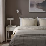 Modern bedroom with beige pre-washed linen cotton duvet set and natural wood bedside table showcasing minimalist decor.