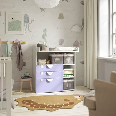Sea-themed nursery with lavender SMÅSTAD changing table, ocean creature wallpaper, stool, and turtle rug.