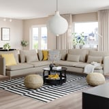 Bright living room with a large beige SÖDERHAMN sofa, black coffee table, striped rug, and a white pendant lamp.