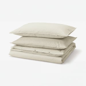 Stacked bedding in beige and white stripes, rectangular, soft cotton.