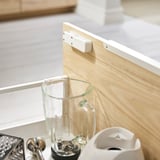 Wooden countertop with a clear blender jar, small grater, and a white kitchen gadget.