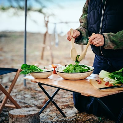Two wooden bamboo kitchen utensils: a large spoon and a slotted serving fork, light brown colour, smooth surface, simple design.
