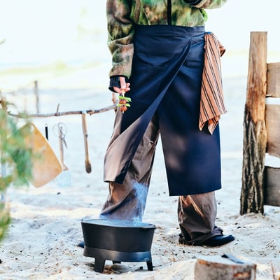 Black SOLUPPGÅNG apron, simple design with straps and pocket, made of 100% cotton.