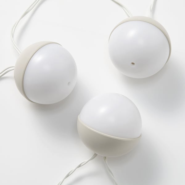 Three spherical white lights, smoothly designed with cord connexions, arranged in a shallow triangular pattern on a clean white surface.