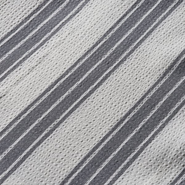Close-up of textured, woven shower curtain with diagonal stripes.