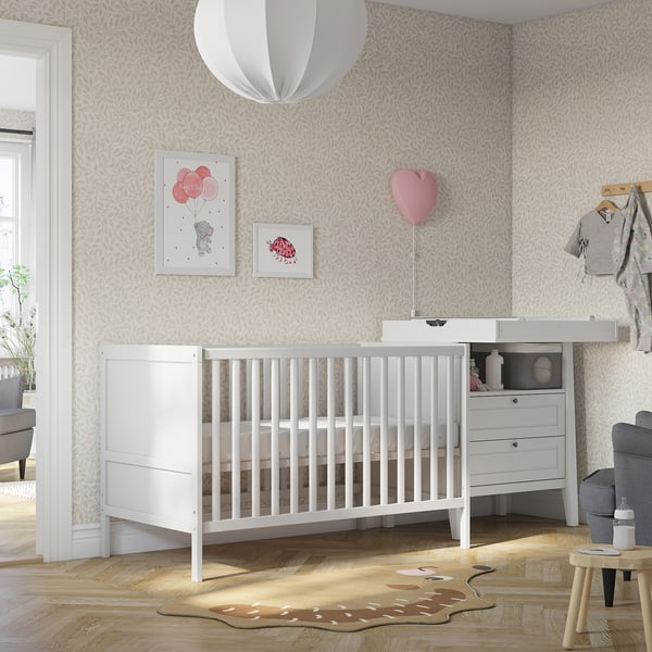Cosy nursery with SUNDVIK crib, dresser, rug, & decor.