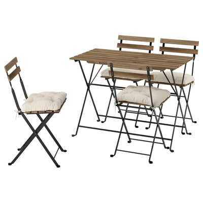 Wooden table and chairs set, outdoor. Light brown, foldable design with cushions.
