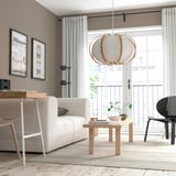 Modern living room with large window, beige sofa, coffee table, unique pendant lamp with floating ribs, wooden floor, light curtains, and framed art.