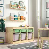 Wooden TROFAST kids storage units with green, grey, and blue bins. Bright, colourful kids room setting.