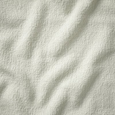 Close-up of a soft, textured white fabric, showcasing its luxurious and cosy feel.
