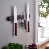Wall magnet with knives: chefs, santoku, paring. Herbs and fruits below.