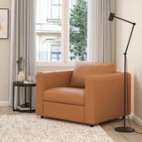 VIMLE: brown leather armchair, modern design, compact, by window, with lamp and side table.