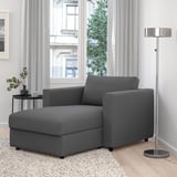 Modern grey VIMLE sectional sofa with storage in a minimalist living room. Wide, boxy design. Large window behind.