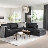 Modern living room with large black VIMLE sectional sofa, wood coffee tables, grey curtains, and large window.