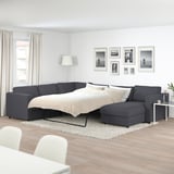 Modern grey VIMLE sofa-bed in minimalist room with large windows & art.