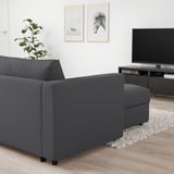 Modern living room with VIMLE dark grey sofa-bed & tv. Sofa with storage & convertible bed function. Tv on stand beside wall art. Plant on left.