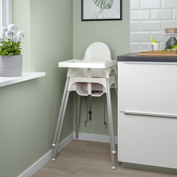 ANTILOP high chair against kitchen counter. Easy to assemble and transport, with removable tray and safety belt. Sturdy and modern design.