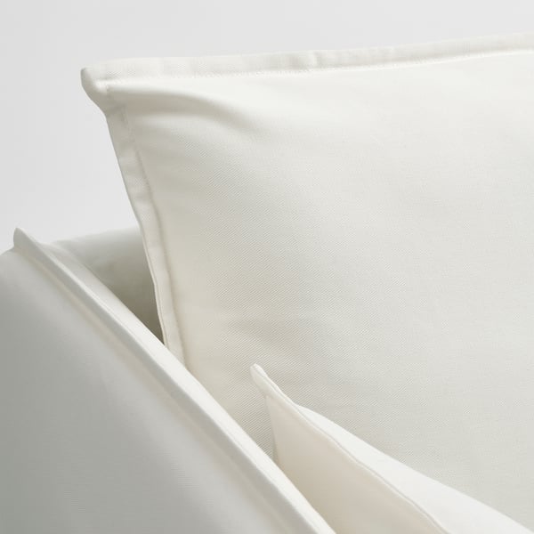 Armchair corner, pristine white fabric, neat stitching, soft texture, inviting comfort