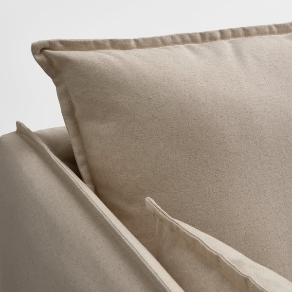 A close-up of a beige sofa cushion with a smooth, natural fabric texture and neat stitching.