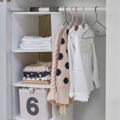 A well-organized closet with hangers, including a multi-functional hanger holding childrens clothes. Shelves have folded clothes and a storage bin.