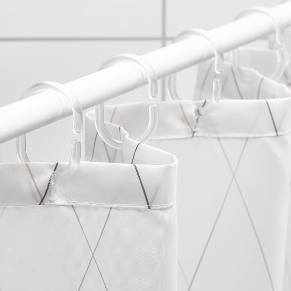 White shower curtain with grey diamond pattern hangs on clear hooks. Water-repellent, dense weave.