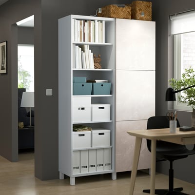 White BESTÅ storage unit with shelves and boxes.
