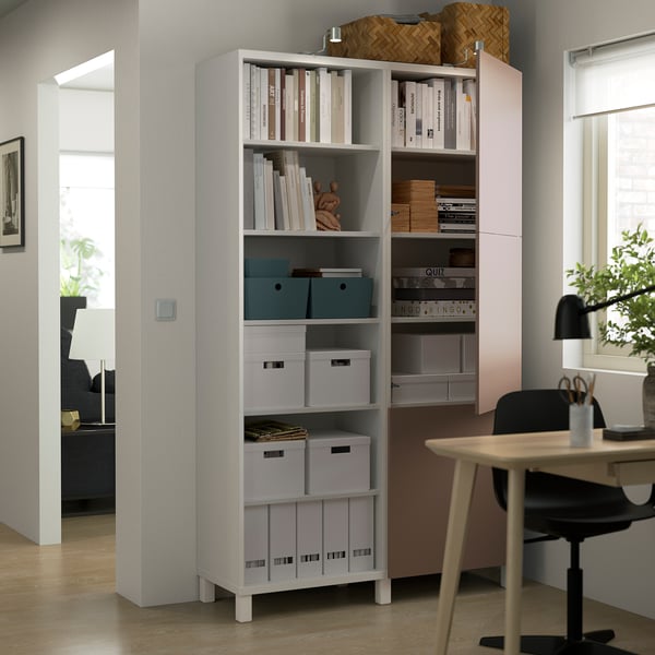 A modern home office a BESTÅ storage unit with adjustable shelves holding books, boxes, and decor, ensuring organised and accessible storage.