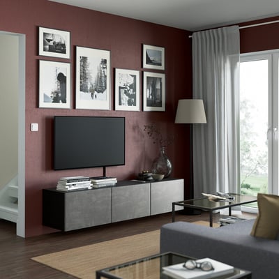 Modern living room with BESTÅ tv bench, grey walls, photos, tall lamp, and large window.