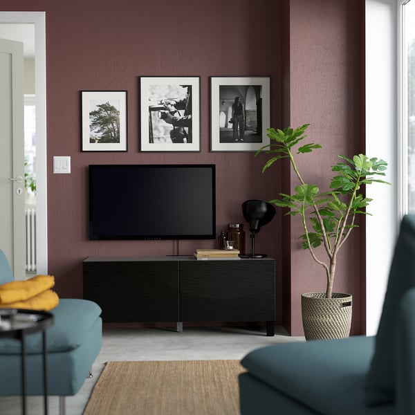 Modern living room with BESTÅ tv stand, photos, plant, & cosy seating.