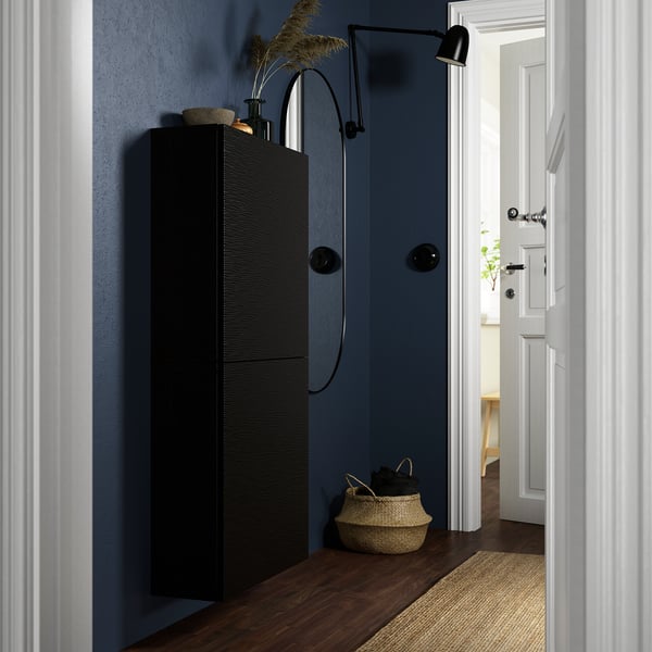 Black BESTÅ cabinet, modern design, tall and narrow, fits corner, stylish decor.