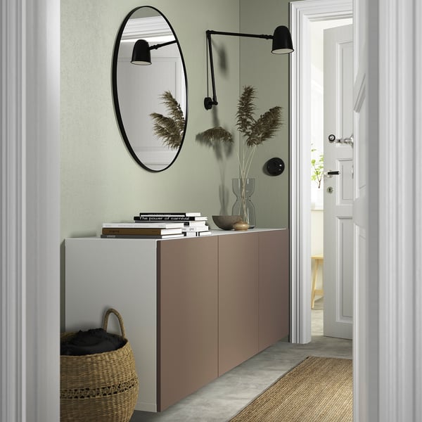 Modern entryway with BESTÅ cabinet, books, and mirror reflecting decor.