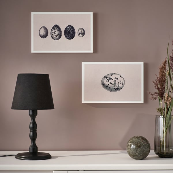 Wall art displayed; lamp and vase on shelf.