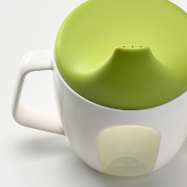 Green lid on white beaker, designed for baby. Handles and spout for easy grip, prevent spills.