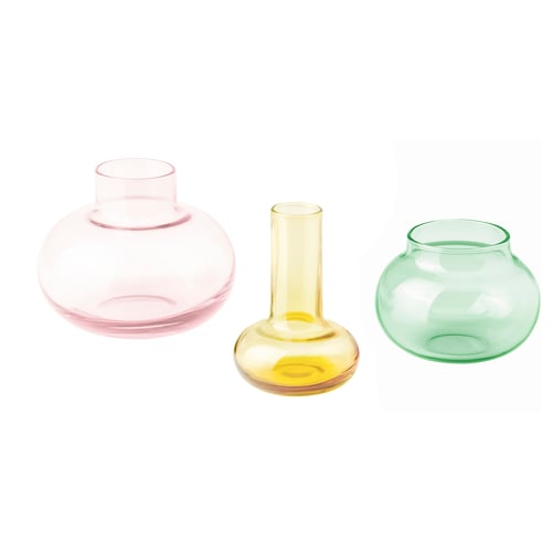 Three colourful glass vases in pink, yellow, and green, each with a unique shape, arranged in a row.