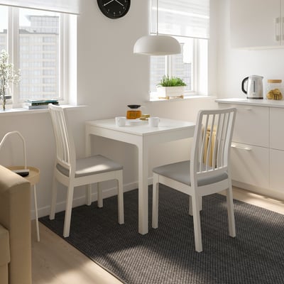 Small white EKEDALEN dining set with extending table, two chairs, and modern decor. Bright, compact, and functional design.