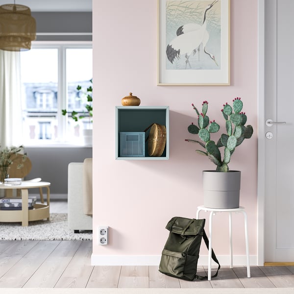 Minimalist room with light pink EKET cabinet, decor, cactus, and city view.